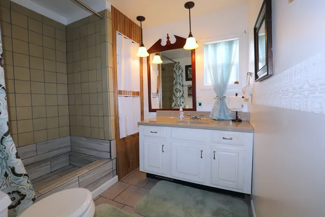 a bathroom with a toilet a sink and mirror