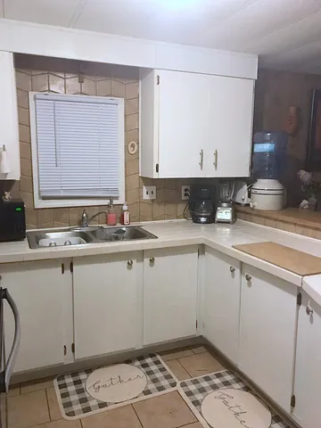 a kitchen with a sink cabinets and window