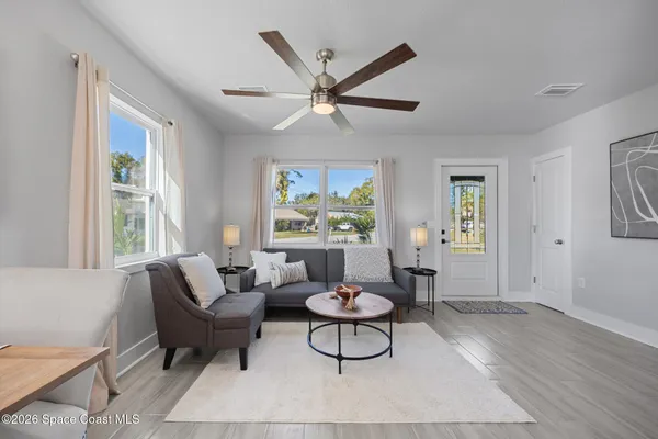 a living room with furniture a window and a ceiling fan