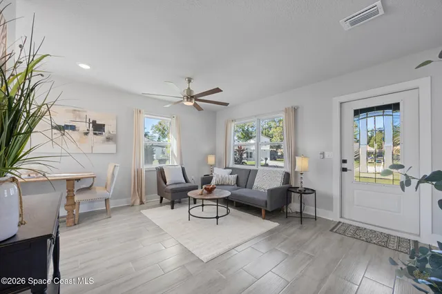 a living room with furniture and a wooden floor