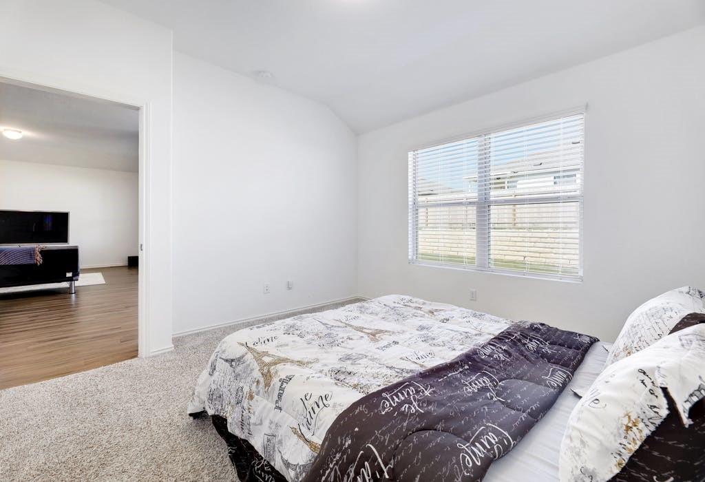 21416 Bird Wing Drive Pflugerville, TX 78660 - Photo 13 of 25 a bedroom with a bed and wooden floor