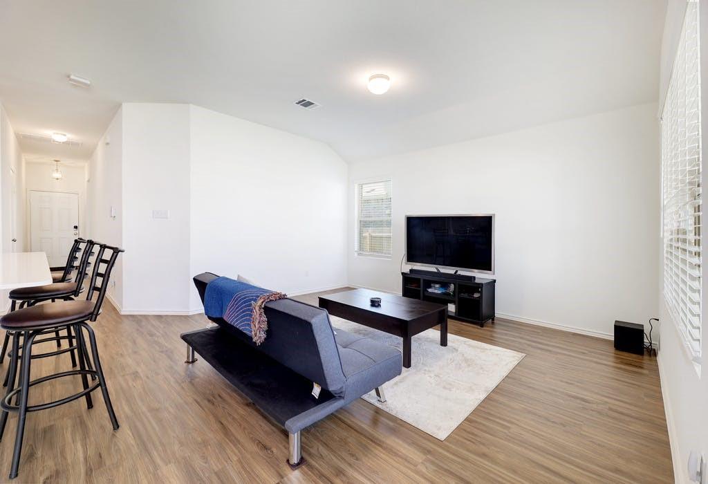 21416 Bird Wing Drive Pflugerville, TX 78660 - Photo 4 of 25 a living room with furniture and a flat screen tv