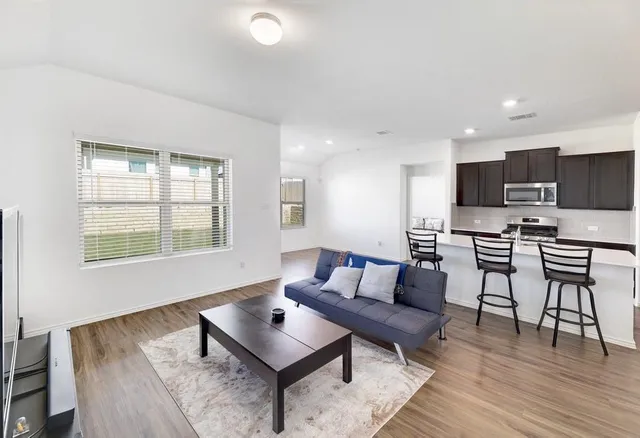 a living room with furniture and a wooden floor