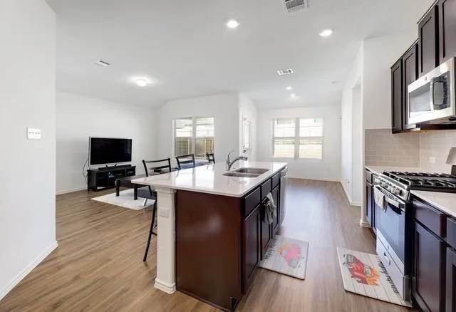a kitchen with stainless steel appliances granite countertop a stove and a sink