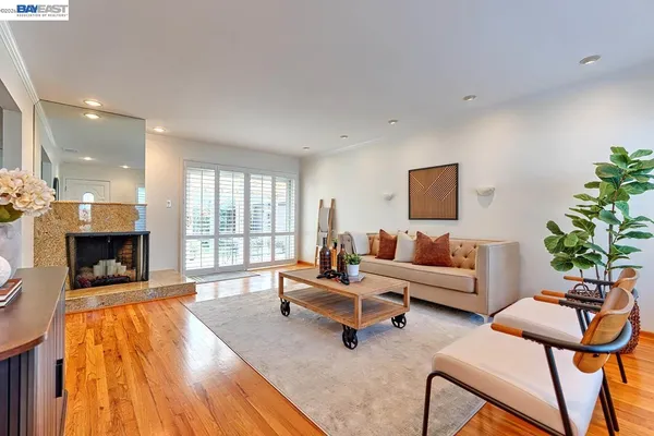 a living room with fireplace furniture and a large window