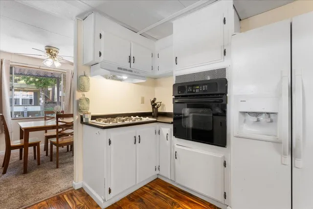 a kitchen with a table chairs microwave and refrigerator