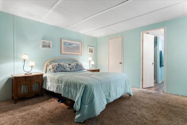 a spacious bedroom with a bed and a lamp