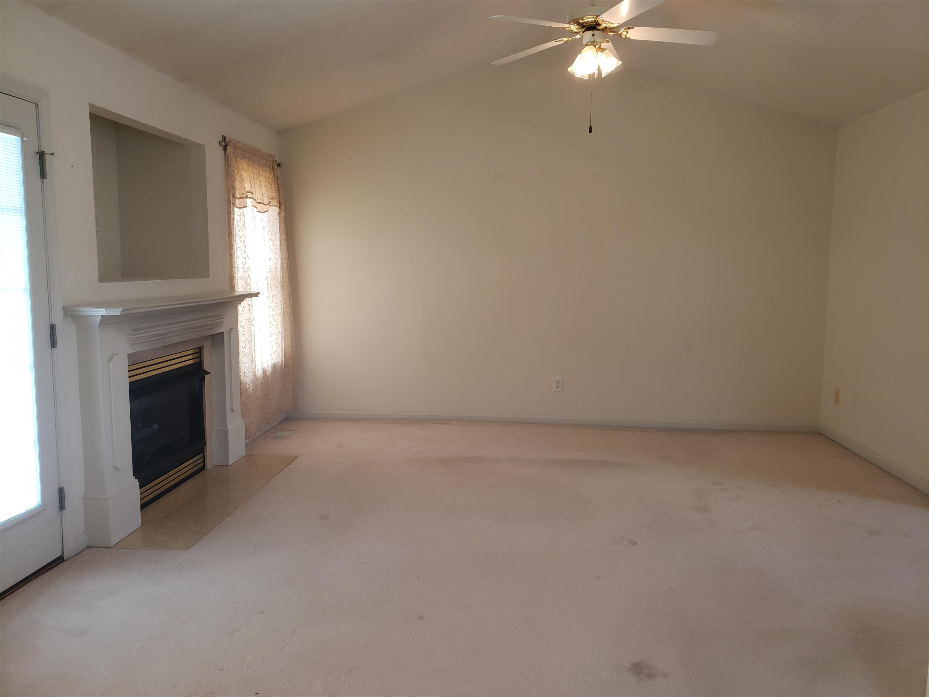 340 Parrish Memorial Road Selma, NC 27576 - Photo 5 of 17 an empty room with a fireplace and fan