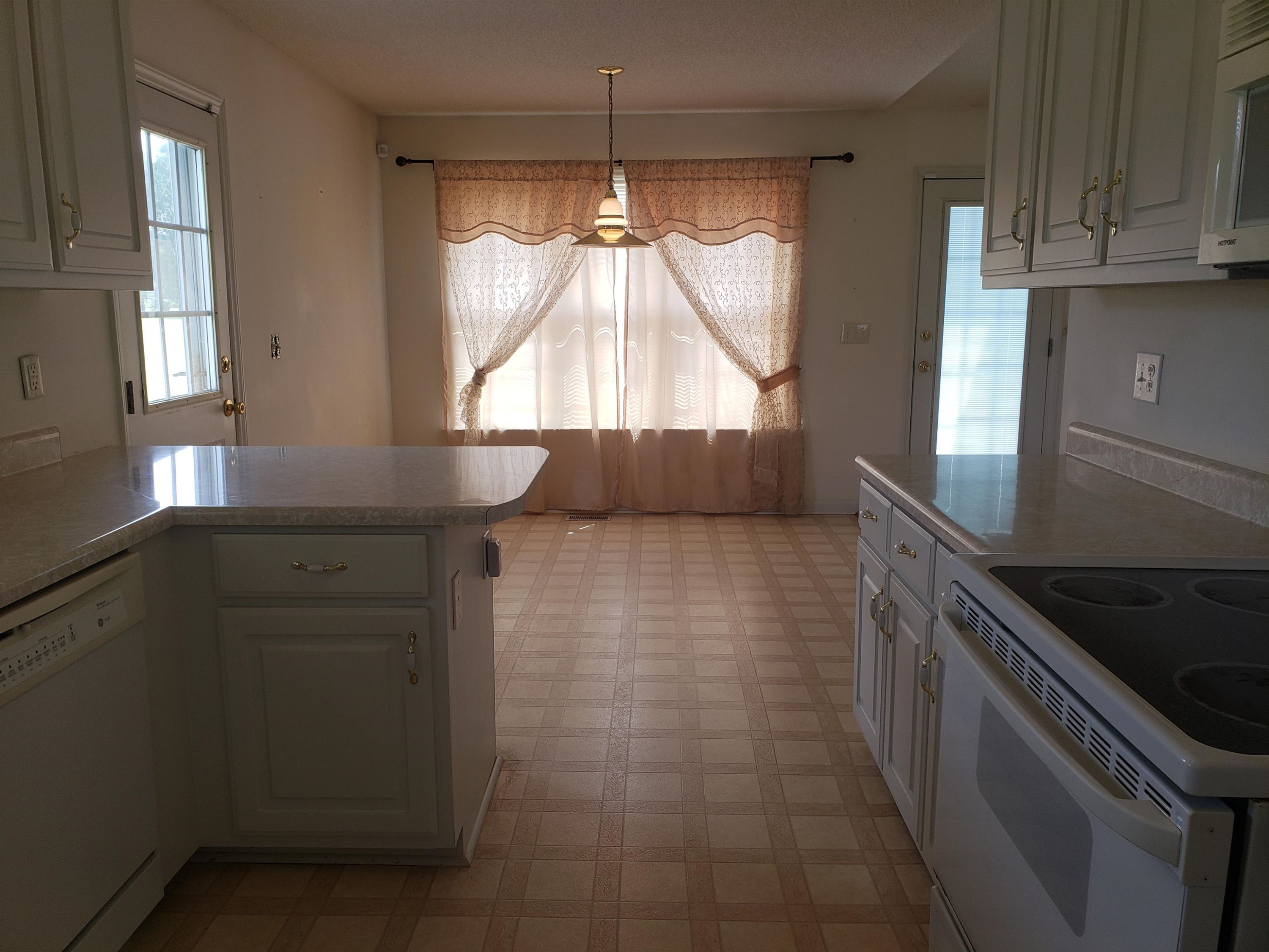 340 Parrish Memorial Road Selma, NC 27576 - Photo 7 of 17 a kitchen with granite countertop white cabinets and window