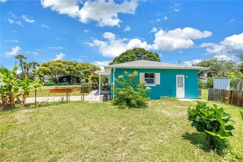 a yellow house with a yard and a wooden fence