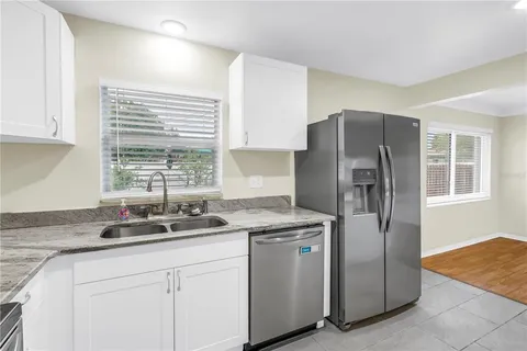a kitchen with stainless steel appliances granite countertop a refrigerator and a sink