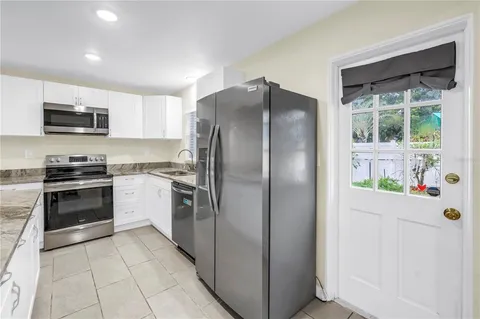 a kitchen with a refrigerator and a stove top oven