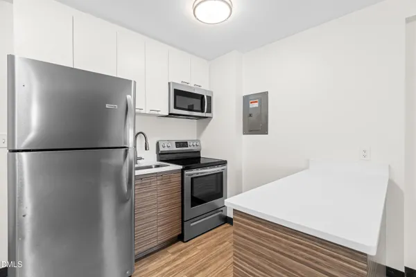 a kitchen with stainless steel appliances a refrigerator sink and microwave