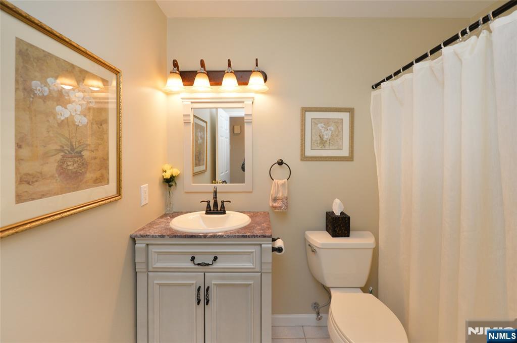 40 Chanda Court, Unit D040 Clifton, NJ 07012 - Photo 11 of 17 a bathroom with a toilet a sink and a mirror