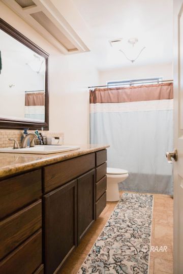 315 Henry Street Ridgecrest, CA 93555 - Photo 26 of 27 a bathroom with a sink a toilet and a mirror