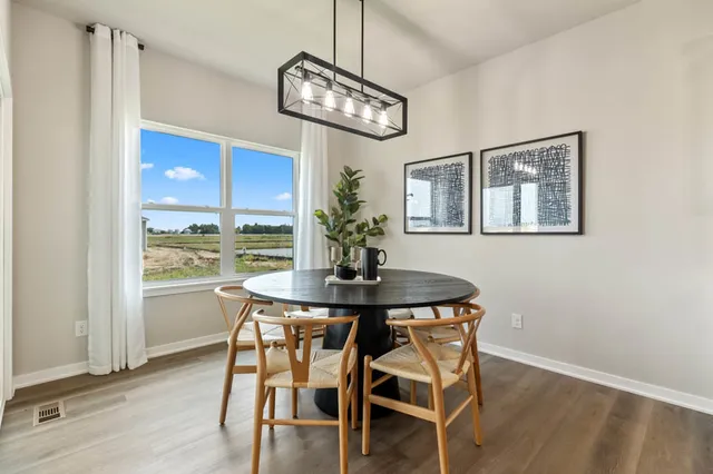 a view of a dining room with furniture a chandelier and wooden floor