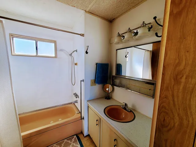 a bathroom with a tub sink and mirror