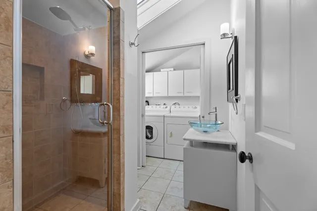 a bathroom with a sink mirror and shower