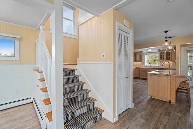 a view of a hallway with wooden floor and staircase