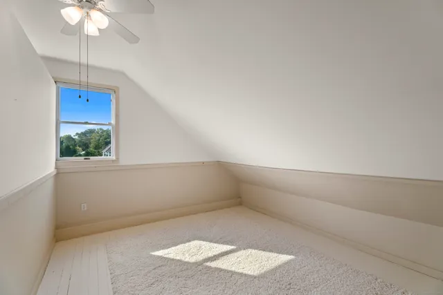 an empty room with a ceiling fan and a window