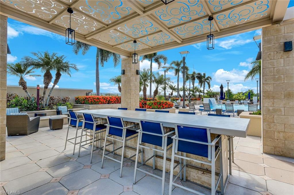9123 Strada Place, Unit 7201 Naples, FL 34108 - Photo 33 of 50 a dining table and chairs in a patio