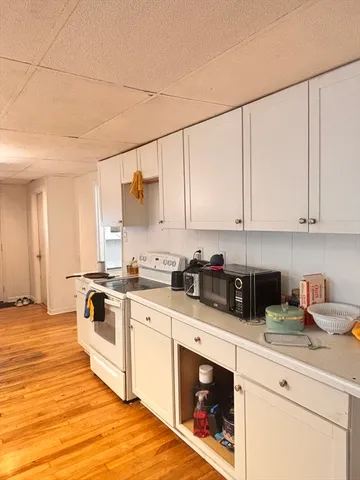 a kitchen with stainless steel appliances granite countertop a stove a sink and white cabinets
