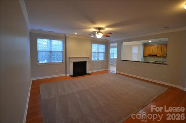 an empty room with windows and fireplace