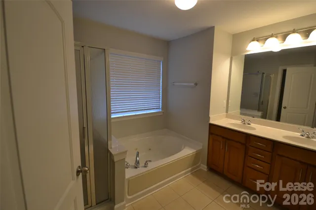 a bathroom with a tub sink and mirror