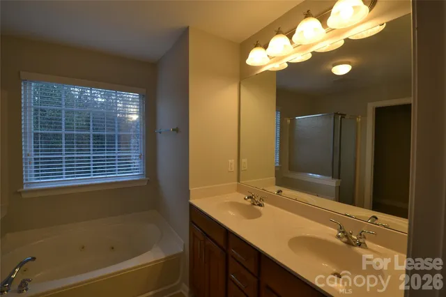 a bathroom with a granite countertop sink a large mirror and a bathtub