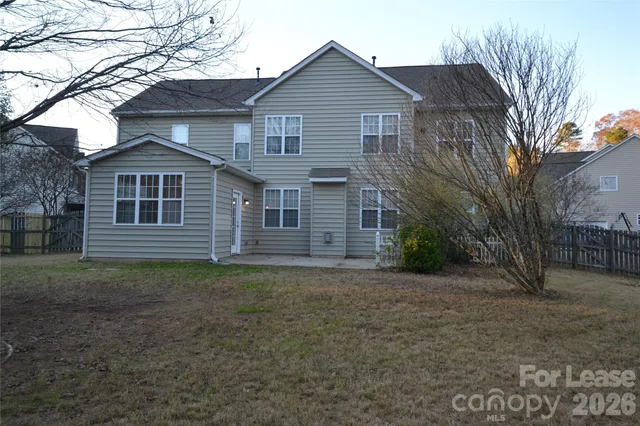 a view of a yard in front of a house with large trees