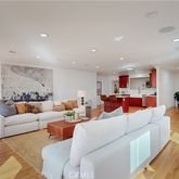 a living room with furniture and a view of kitchen
