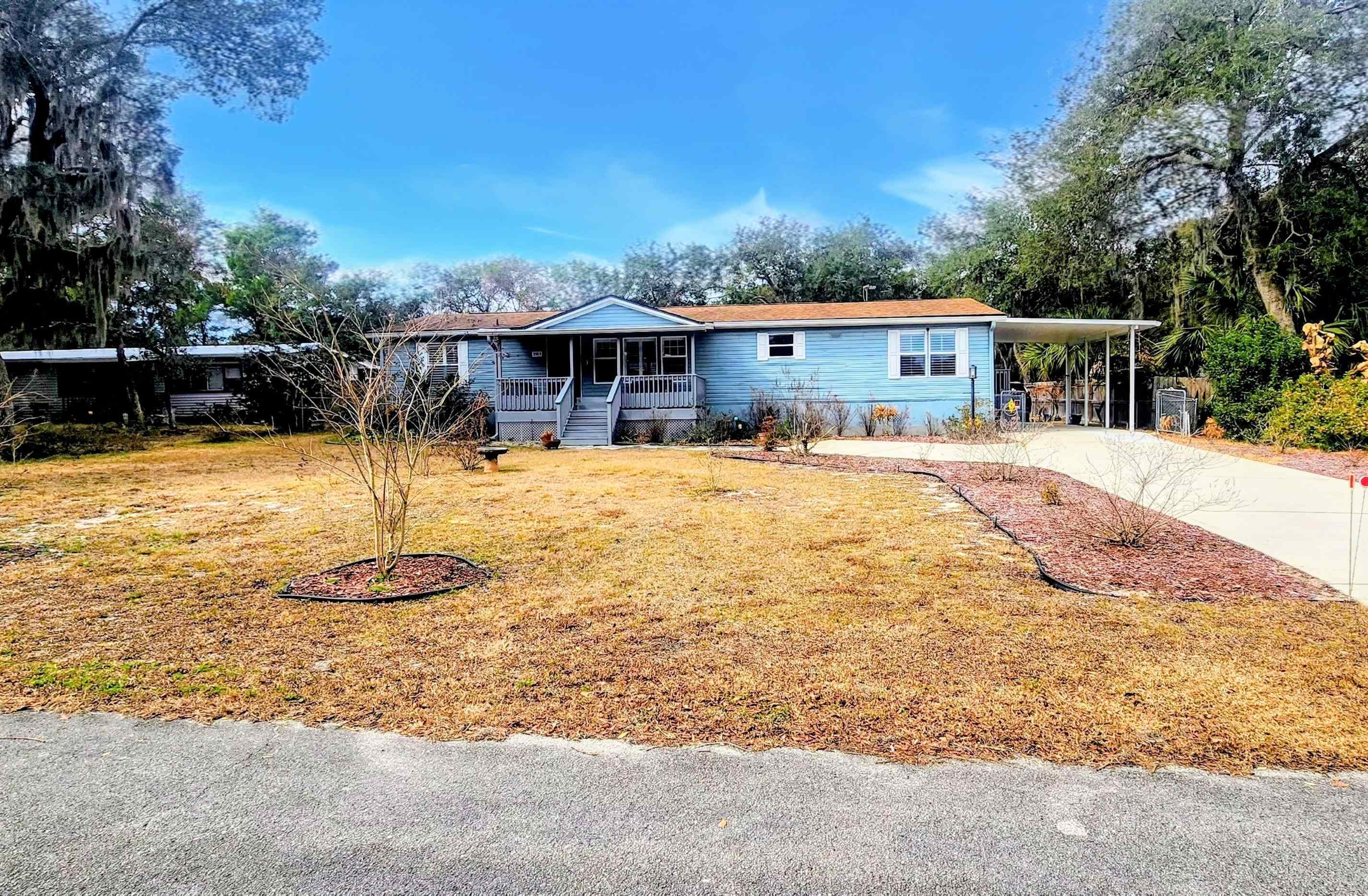 3969 Oak Terrace Road St. Augustine, FL 32086 - Photo 2 of 29 Manufactured / mobile home with an attached carport, a front yard, concrete driveway, and a porch