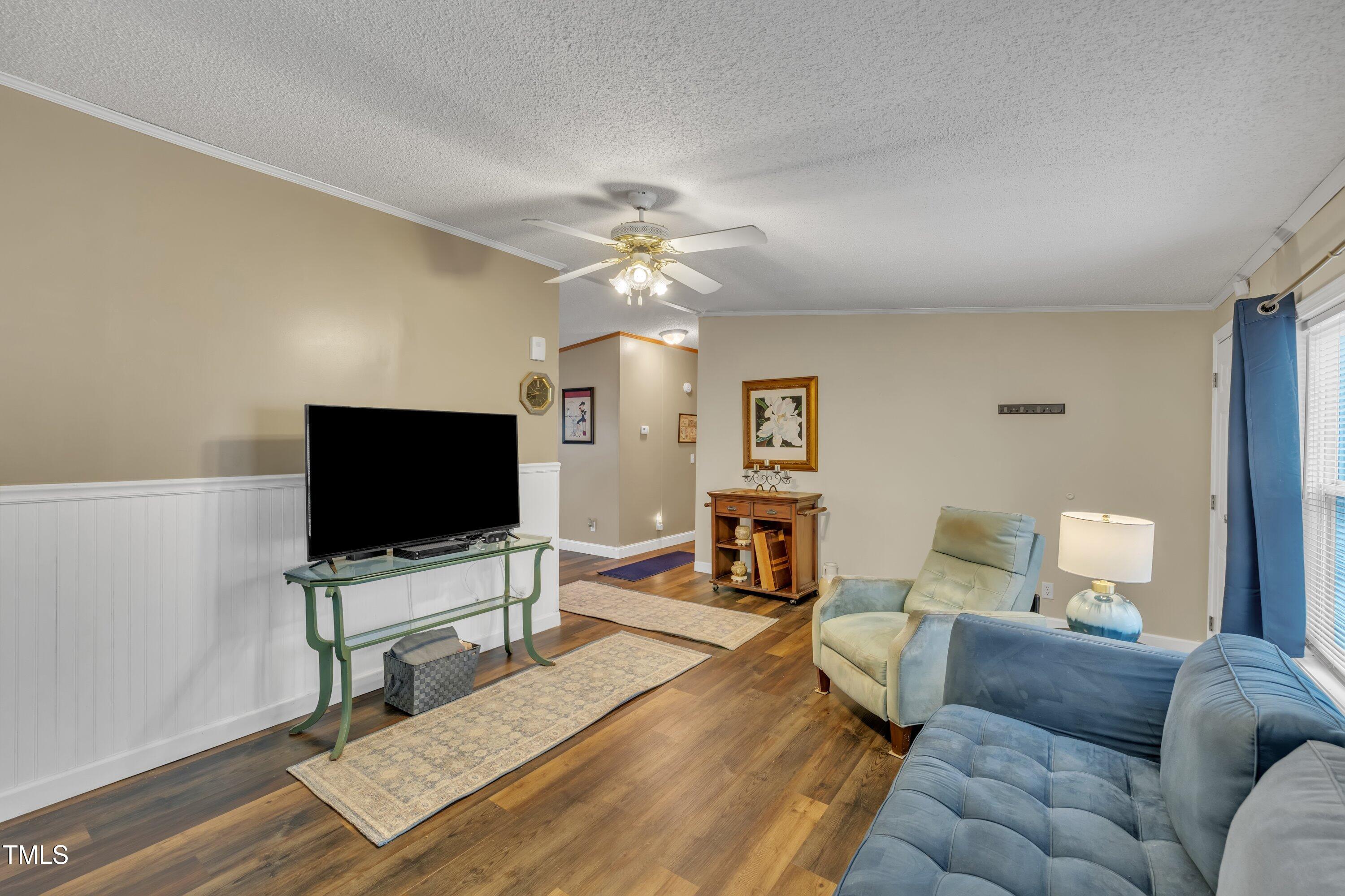8904 Kennebec Road Willow Spring, NC 27592 - Photo 8 of 42 a living room with furniture and a flat screen tv