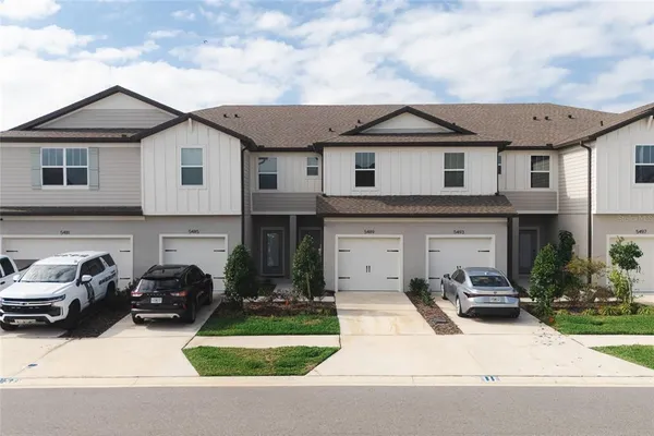 a view of a white house with a yard and plants