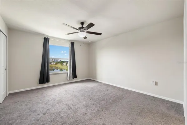 an empty room with windows and a ceiling fan