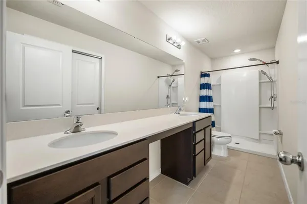 a bathroom with a granite countertop sink a toilet and a mirror