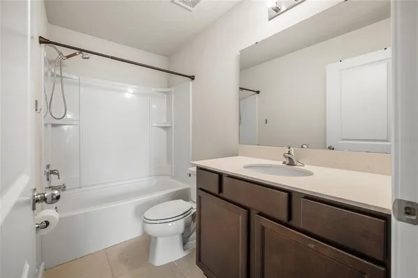 a bathroom with a granite countertop sink toilet a shower and a mirror