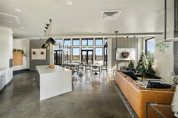 a living room with furniture and a dining table with floor to ceiling window