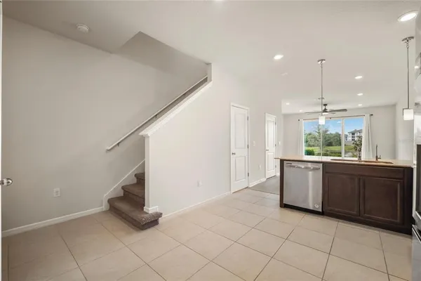 a large white kitchen with a sink and dishwasher a stove top oven with wooden floor