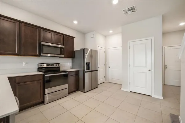 a kitchen with granite countertop a refrigerator and a stove top oven
