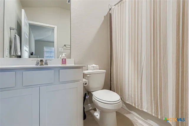 a bathroom with a toilet a sink and a mirror