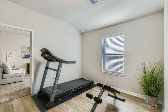 a living room with furniture gym equipment and a window