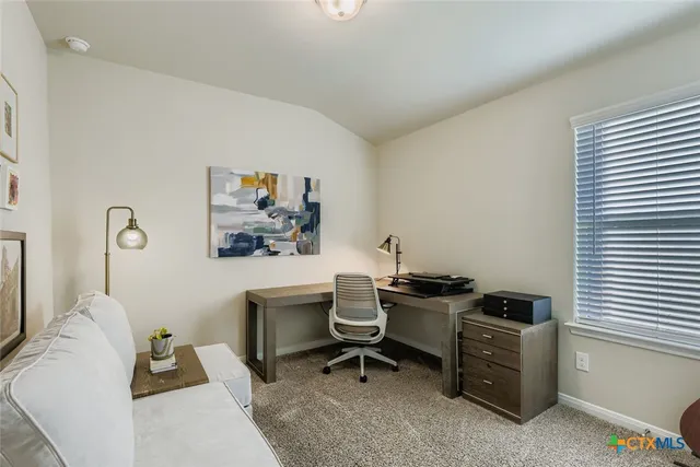 a view of a workspace with furniture and a window
