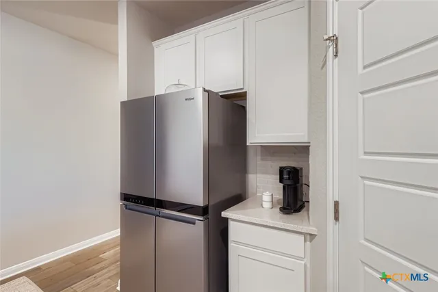 a kitchen with a refrigerator and cabinets