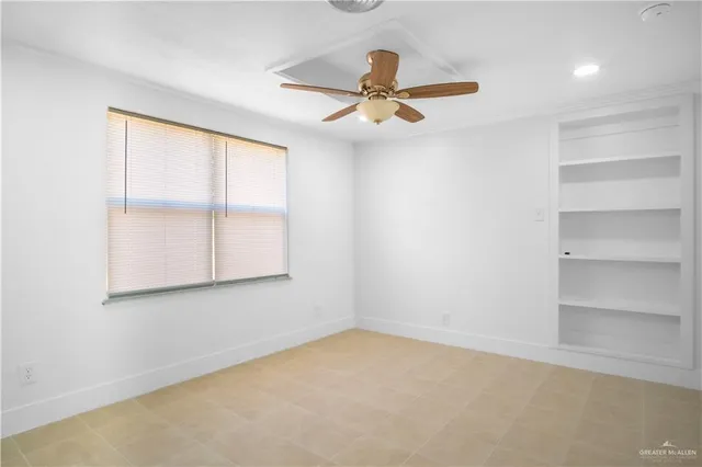 an empty room with a window and ceiling fan