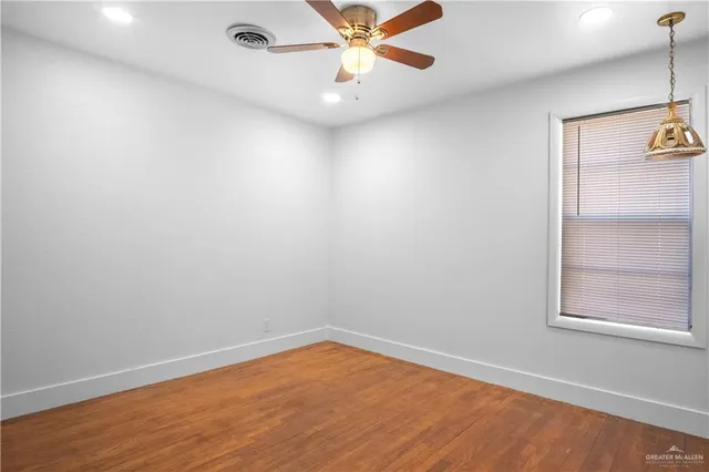 an empty room with a window and ceiling fan