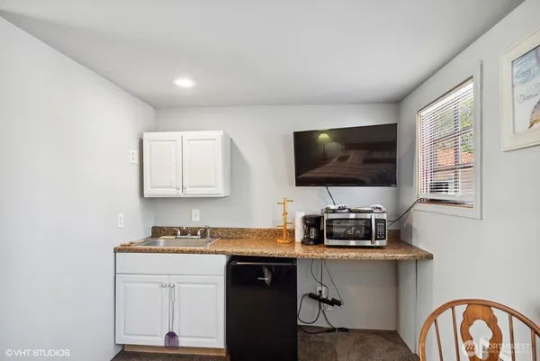 a kitchen with stainless steel appliances white cabinets and a window