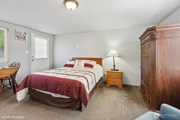 a bedroom with a bed a chair and a flat screen tv