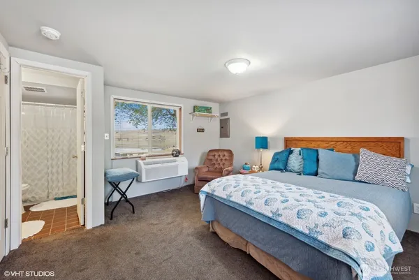 a bedroom with a bed and a large window