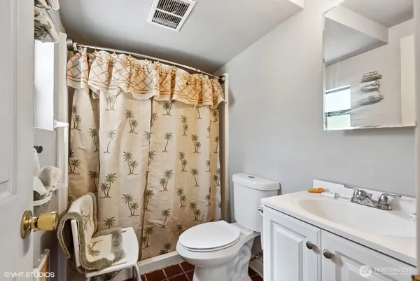 a bathroom with a sink toilet vanity and shower